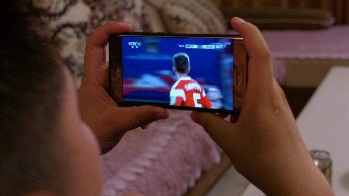 男人看足球比赛手机观看