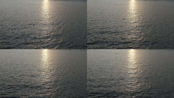 阳光洒在海面上，波光粼粼的水面，逆光镜头