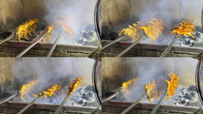 烧烤店的厨师使用炭火来烧烤整鸡，炭火烤鸡