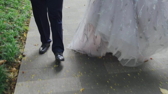 穿着婚纱的姑娘和行走黑色脚步皮鞋