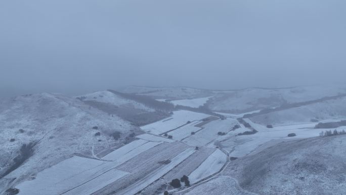 航拍风雪交加的山脉田野