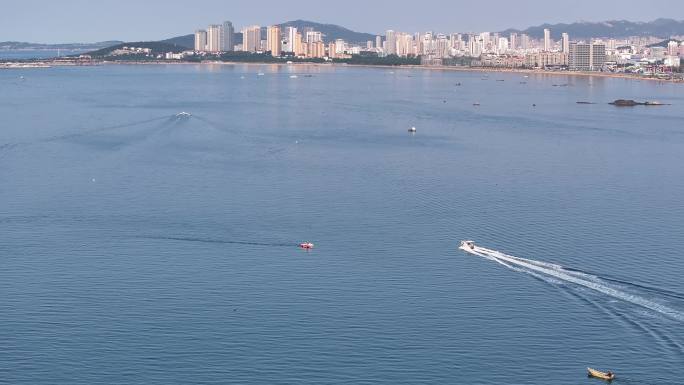 航拍俯瞰威海双岛湾海面上高速航行的快艇