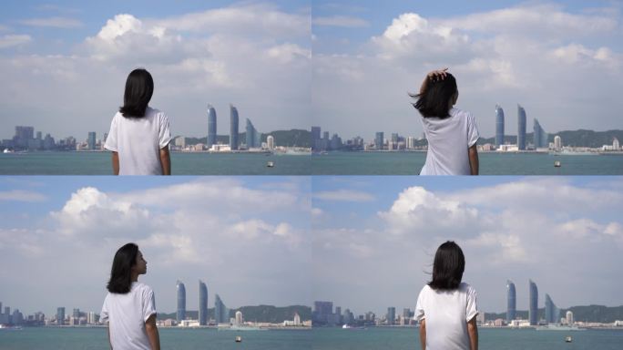 女孩站在城市海边吹风看风景看海青春少女