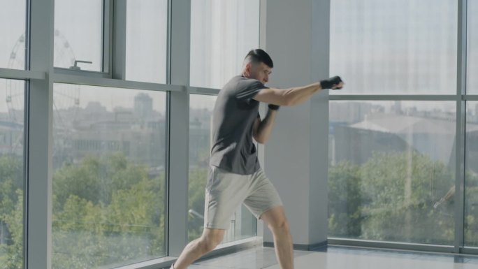 慢动作的年轻运动员双手包裹在练习拳击动作享受武术在健身房