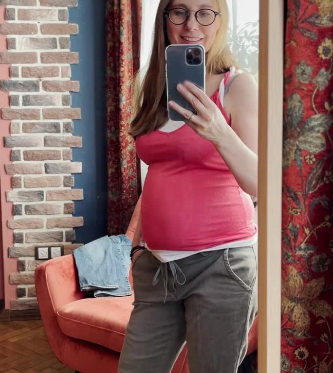 孕妇用智能手机用镜子拍视频自拍