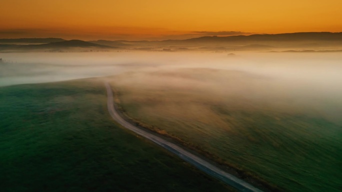 无人机视角的雾霭笼罩着日出时田园诗般的宁静乡村风景