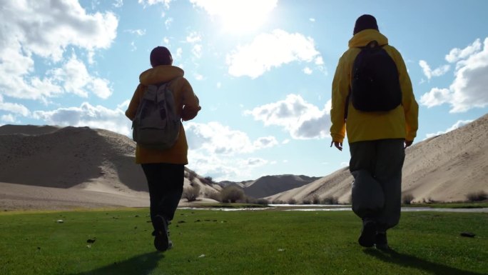 由四个徒步旅行者组成的旅行团沿着沙漠地区向前走