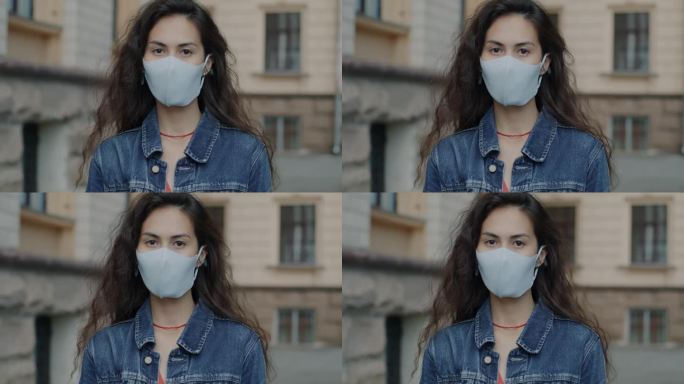 戴着口罩站在城市里的亚洲妇女的慢动作肖像，在冠状病毒大流行中幸存下来