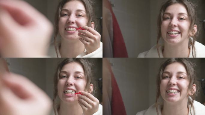 白人妇女用牙间刷清洁牙间间隙。专业的口腔护理。矫正牙齿咬伤