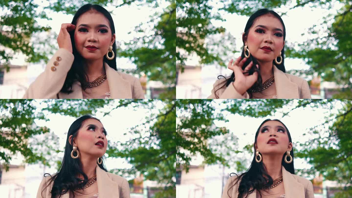 一个优雅的亚洲女人，戴着金耳环，化着妆，看着一家豪华酒店