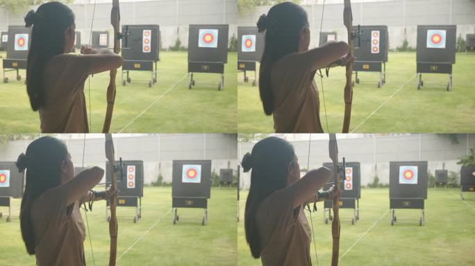迷人的亚洲女性在靶场练习射箭。射箭。