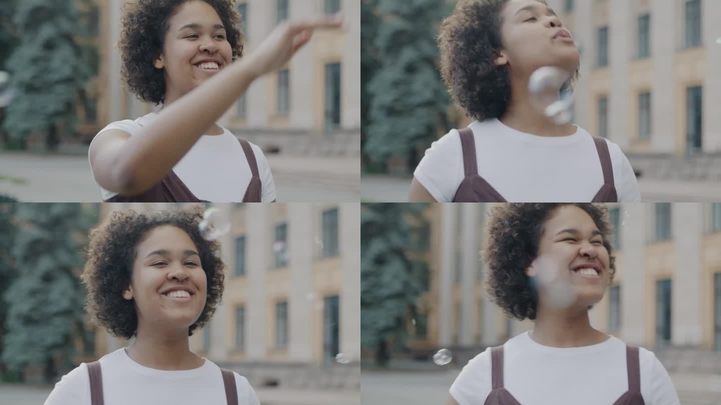 慢动作，快乐的年轻非裔美国妇女玩肥皂泡，笑着在城市街道外面玩