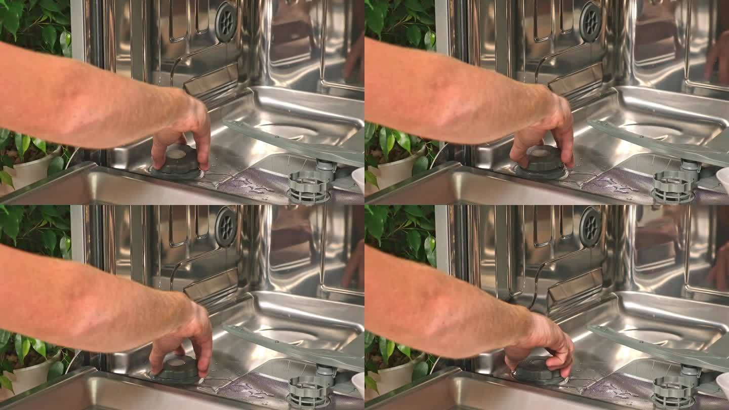 男子打开洗碗机的盐盒，将盐通过漏斗倒入。软化硬度水