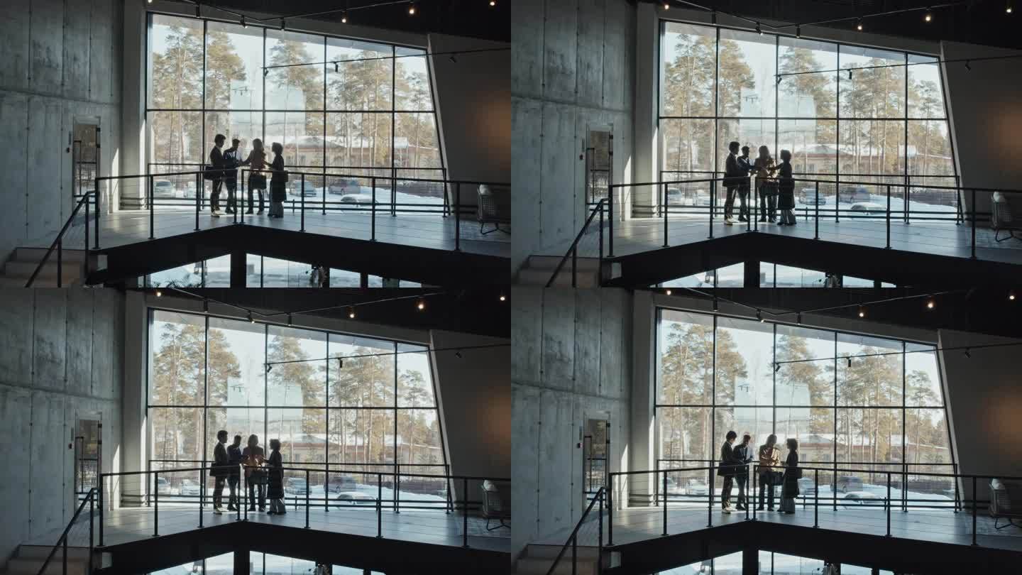 一群商务人士在高窗的宽敞大厅里握手