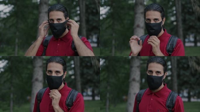 阿拉伯男子背着背包，戴着医用口罩站在城市户外的慢动作肖像