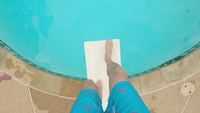 从POV的角度看脚走在跳水板上，在游泳池里跳