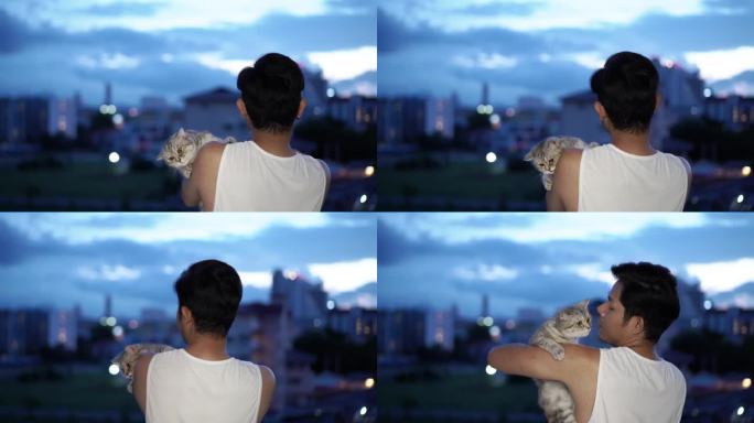 一个亚洲男人在阳台上和一只猫玩耍
