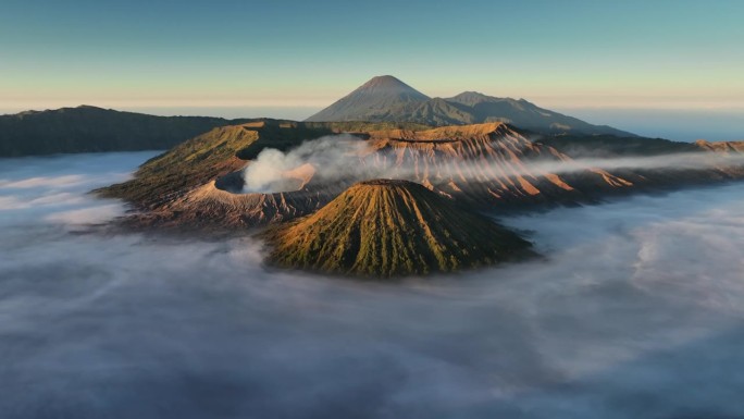 空中无人机拍摄的印尼爪哇岛东爪哇岛腾格里火山口喷发火山Bromo火山的日出场景，周围有云、雾和烟，还