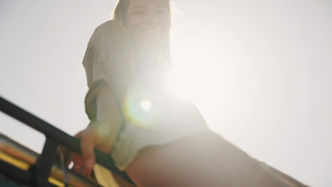 一名年轻女子在露营车的车顶上享受夏日的微风