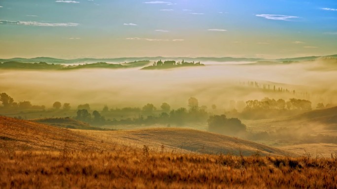 时间流逝的雾在阳光下移动，日出时田园诗般的起伏景观
