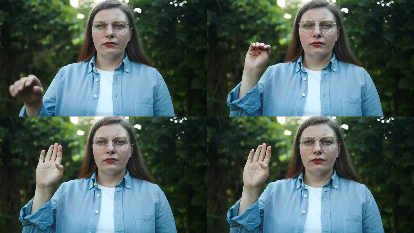 发出求救信号。一名女子在户外展示如何用手势无声地寻求帮助