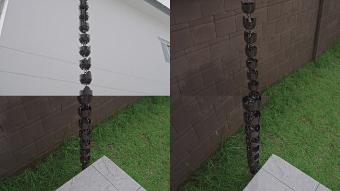 SLO MO:雨水从上到下落在设计精美的金属雨链上，背景是白色的外墙。