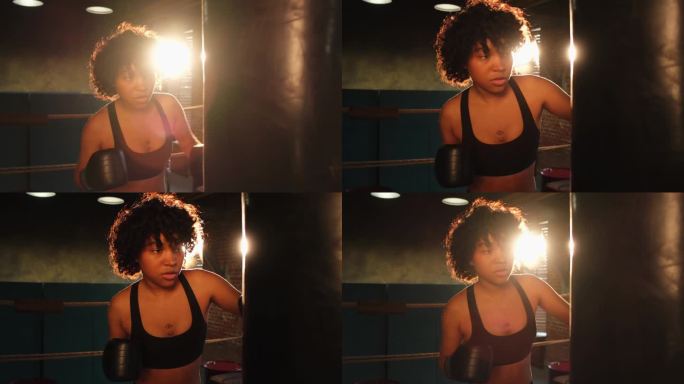 女性自卫，女性力量。非裔美国女拳手在拳击台上训练出拳。健康强壮的女孩拳击袋。拳击馆训练日。力量健身健