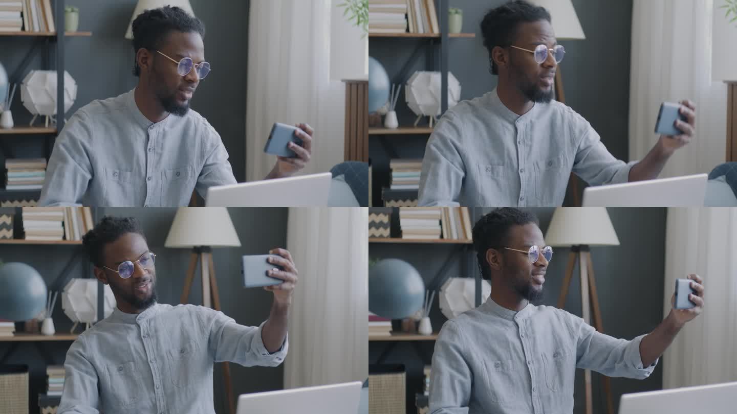 友好的非裔美国学生在家里用智能手机聊天和打手势进行在线视频通话