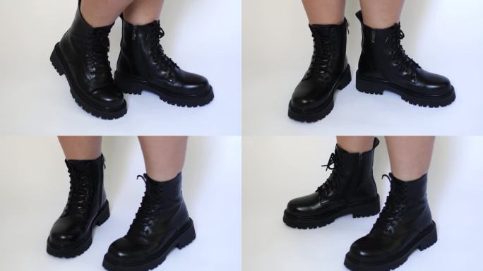裁剪后的照片显示，一名女子穿着系着鞋带的黑色靴子，在白色背景上踮着脚尖转过身来。特写镜头。