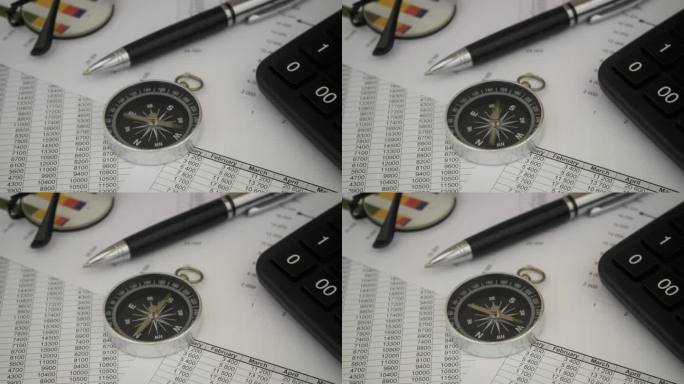 用笔、眼镜和计算器在财务报告上旋转指南针。
