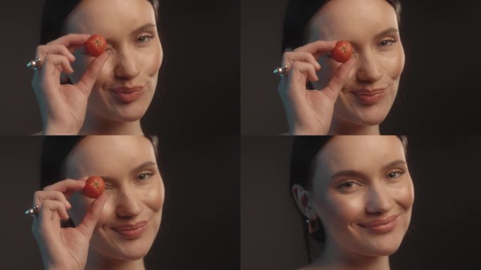 性感的女人用红色的口红黑色的背景工作室拍摄的姿势，草莓在她的眼睛