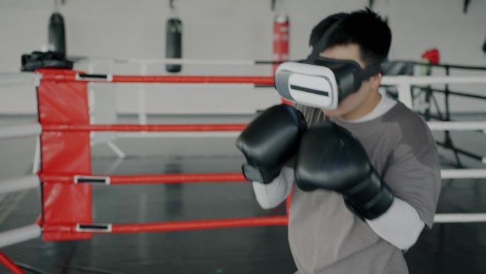 年轻人戴着拳击手套在健身房训练，戴着虚拟现实眼镜享受休闲时光