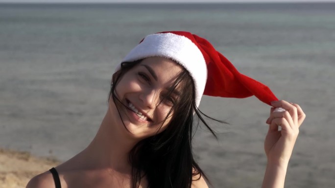 岛上戴着新年帽的快乐女人。这个女孩在棕榈树间庆祝圣诞节。