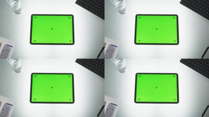 平板电脑的顶部放大视图，模拟绿屏Chromakey显示器和运动追踪器站在办公桌上，旁边是键盘，黑色钢