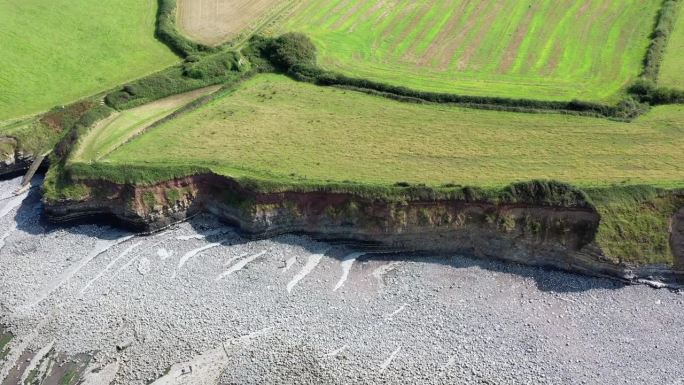 无人机在英国北德文郡基尔夫海滩及其海崖上从左到右移动时拍摄的照片