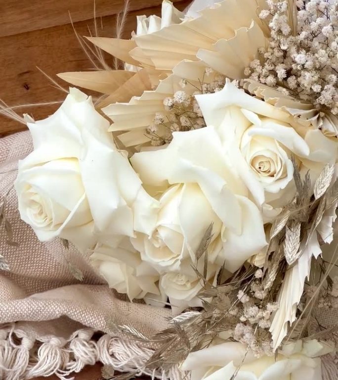 波西米亚木椅上的婚礼花束和白玫瑰