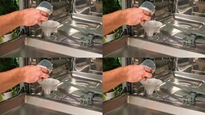男子打开洗碗机的盐盒，将盐通过漏斗倒入。软化硬度水