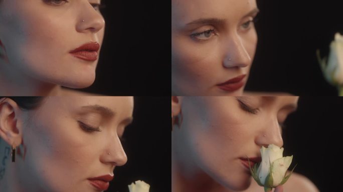 性感的女人与红色的口红黑色背景工作室拍摄的姿势与一个单一的白玫瑰。闻花香