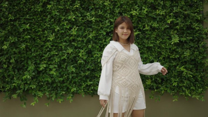 在泰国，一个身穿白衣的泰国女孩对着镜头微笑