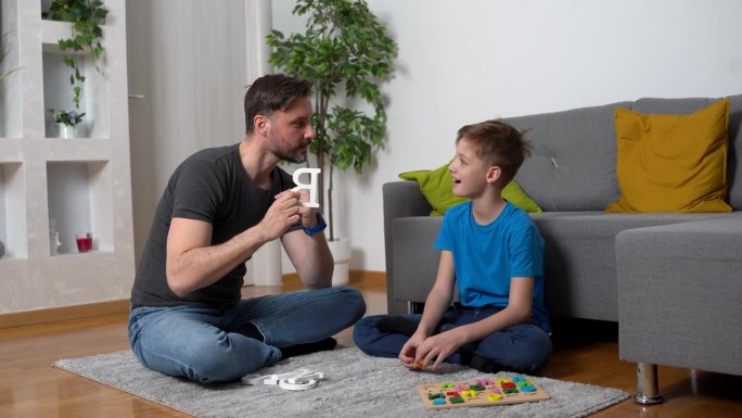 成人语言治疗师支持男孩在客厅的语言发展