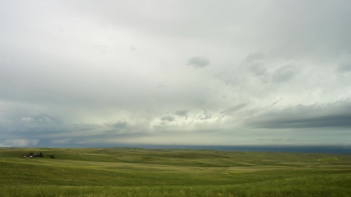远处的暴风云穿过美丽开阔的绿色山丘和乡村