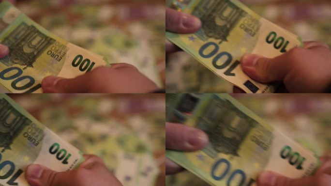 两个人正在分钱，男人的手用力地拉着一叠100欧元的钞票
