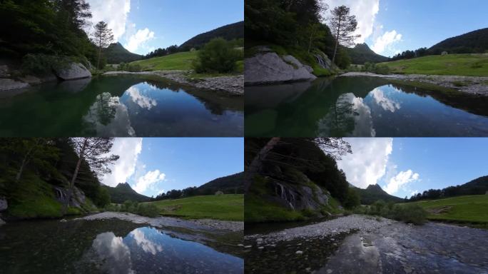 一架无人机在河流、山脉和瀑布上空飞行的壮观航拍图像。水里有壮观的倒影