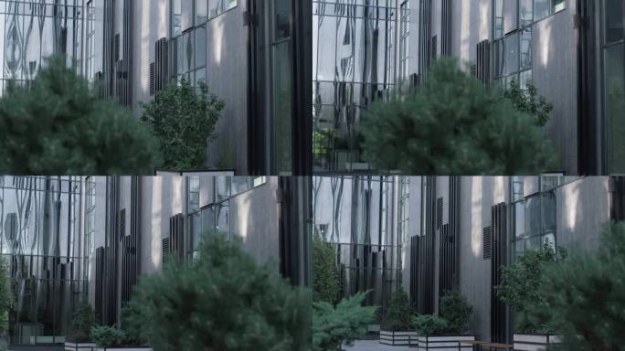 公司办公玻璃大楼里的绿树。未来主义市区概念