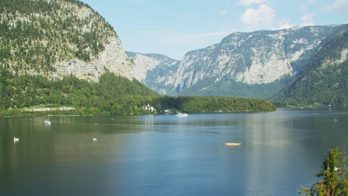 哈尔施塔特湖上的船只航行和山脉背景在一个夏天的一天
