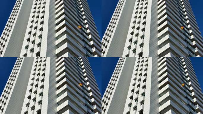小小的西班牙国旗在现代摩天大楼中飘扬