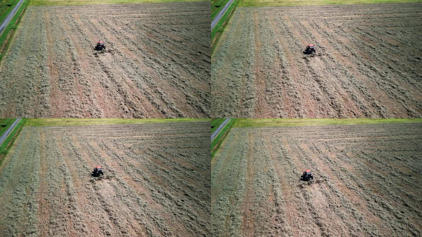 一架拖拉机翻动干草准备收割的航拍照片