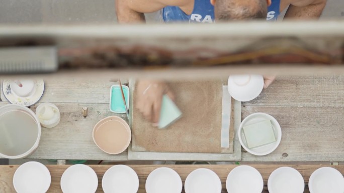 陶瓷厂工人用海绵清洗碗