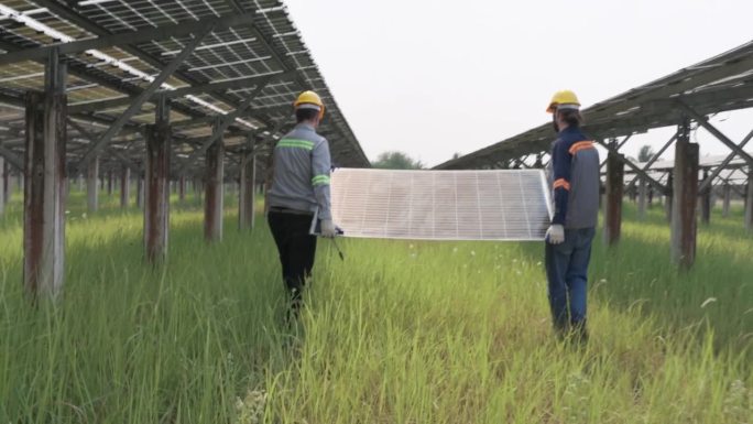 Two male technician carry solar cell to install