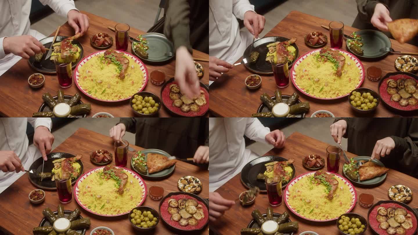 穆斯林家庭聚餐，一起吃饭，阿拉伯菜。斋月，宗教节日，神圣的月份。茄子蒸粗麦粉，桌上有美味的米饭和肉。